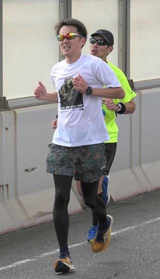 浜手バイパスの坂を上り切り、走りに力を込める大西一行さん＝１９日午後、神戸市中央区（撮影・風斗雅博）
