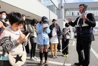 普段は入れない制限区域内で取材をする子ども記者ら＝神戸空港