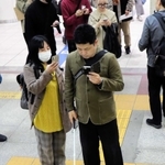 スマートフォンでコードを読み取りながら目的地を目指す男性＝ＪＲ三ノ宮駅