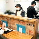 カウンターの客と会話を楽しむ留学生ら＝兵庫区東山町２