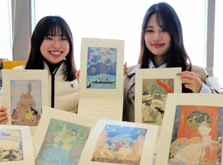 ジョルジュ・バルビエの作品を基に制作したカレンダーをＰＲする神戸松蔭女子学院大の藤村樹音さん（左）と三村佳穂さん＝神戸新聞社