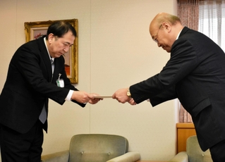 藤原政幸水道事業管理者（左）に答申書を手渡す柳川隆会長＝神戸市役所