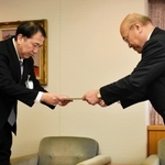 藤原政幸水道事業管理者（左）に答申書を手渡す柳川隆会長＝神戸市役所