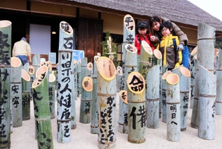 被災地への祈りを記した竹灯籠が並ぶ＝神戸市北区山田町藍那、あいな里山公園