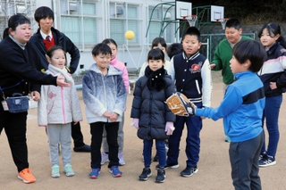 大谷翔平選手から寄贈されたグラブを手に、初めてのキャッチボールに挑戦する児童ら＝神戸市北区有馬町