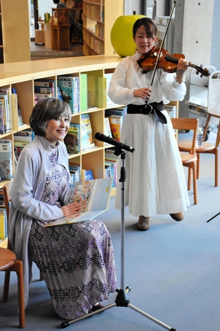 バイオリンの演奏に合わせて絵本を朗読する竹下景子さん（左）＝神戸市中央区加納町６、こども本の森神戸
