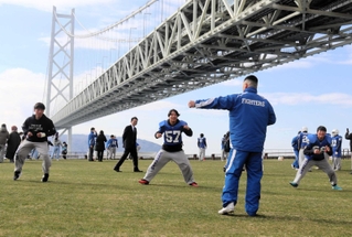 甲子園ボウルで使われた芝生の上で関西学院大の選手から指導を受ける星陵高の選手ら＝舞子公園