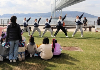 芝生移設のセレモニーでは関西学院大チアリーダー部が駆け付け、演技を披露した＝舞子公園