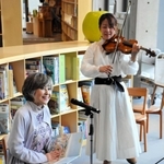 バイオリンの演奏に合わせて絵本を朗読する竹下景子さん（左）＝神戸市中央区加納町６、こども本の森神戸