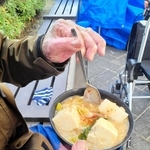 年末の炊き出しでマーボー丼を食べる男性＝２０２３年12月30日午後、神戸市中央区加納町６、東遊園地（撮影・高田康夫）