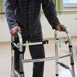 歩行器を使って歩く男性。火災後、歩けるようになるまで５カ月かかった＝神戸市長田区