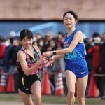 女子・西区の２区池野絵莉選手（右）からたすきを受ける３区池野芹梨選手＝加古川市の加古川河川敷マラソンコース（撮影・笠原次郎）