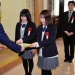 久元喜造市長（左）から表彰状を受け取る受賞者＝神戸市役所