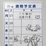 垂水小学校の発掘調査事業の週間予定表に描かれた「イセキにゃん」と「レキシにゃん」の絵