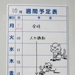 垂水小学校の発掘調査事業の週間予定表に描かれた「イセキにゃん」と「レキシにゃん」の絵