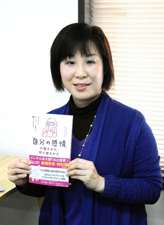 著書を手にメンタル本大賞の最優秀賞と特別賞に選ばれたことを喜ぶ高井祐子さん＝神戸心理療法センター