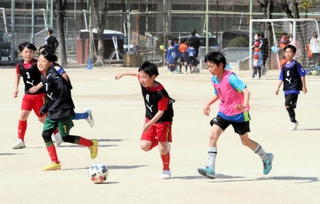 一緒にサッカーを楽しむ能登と神戸の児童ら＝神戸市東灘区魚崎南町１