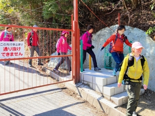ゲート脇に設置された扉を通るハイカー＝神戸市北区山田町（神戸市提供）