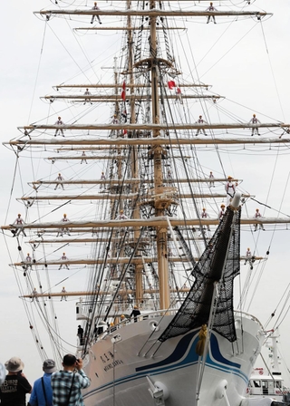 シンガポールに向け出航した海王丸。実習生らが「登檣礼」を披露した＝神戸港新港第１突堤