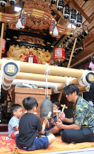 青年会のお兄さんと一緒に半鐘を叩く子どもたち＝神戸市東灘区御影２