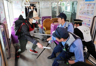 ポートライナー車両内で不審者役を制圧する警察官ら＝神戸市中央区港島中町７