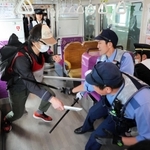 ポートライナー車両内で不審者役を制圧する警察官ら＝神戸市中央区港島中町７