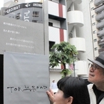 トアロードのアーチに刻字された新曲「トアロードのハレ娘」の歌詞を除幕する松本隆さん（右）＝神戸市中央区北長狭通