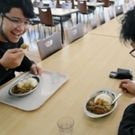すき焼きのもとをアレンジしたカレーをほおばる学生＝神戸国際大