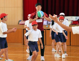 子どもたちとドッジボールを楽しむヴィッセル神戸の山川哲史選手（中央）＝西区櫨谷町池谷、櫨谷小