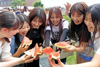 冷えたスイカを味わう学生たち＝神戸市須磨区東須磨青山