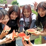 冷えたスイカを味わう学生たち＝神戸市須磨区東須磨青山