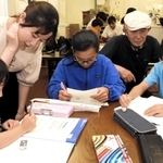放課後に集まり、宿題に取り組む子どもたち。学生ボランティアや中村保佑さん（右から２人目）が見守る＝神戸市東灘区甲南町２