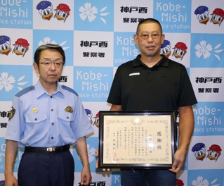 感謝状を受け取った松浦晋也さん（右）と神戸西署の後藤斉久署長＝神戸西署