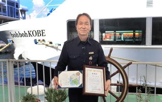 のじぎく賞と感謝状を受け取った西子貞雄さん＝神戸市中央区波止場町