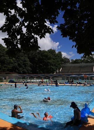 緑に囲まれた都心のオアシス。最後の夏を惜しむように、親子連れらが水の中で元気にはしゃいでいた＝神戸市灘区王子町、王子スポーツセンター（撮影・長嶺麻子）