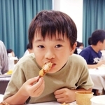 特定外来生物「ウシガエル」の唐揚げにかぶりつく子ども＝長田区苅藻島町３