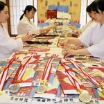 七五三祝いの千歳飴を袋に詰める巫女ら＝生田神社