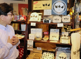 「有馬三羽烏」グッズを紹介する吉田佳展さん＝北区有馬町、吉高屋
