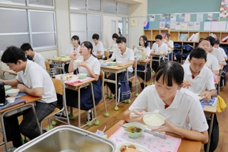 温かい給食をほおばる生徒たち＝神戸生田中