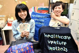神戸フォントが使われた製品を紹介する山田愛さん（左）と喜多一馬さん＝神戸市長田区腕塚町５