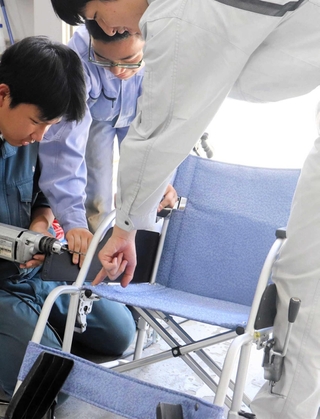協力して車いすを整備する生徒＝科学技術高校