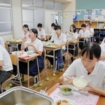 温かい給食をほおばる生徒たち＝神戸生田中