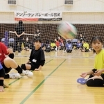 実業団バレーボールチームの選手と一緒にシッティングバレーを体験する子どもたち＝デンソーテン体育館