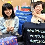 神戸フォントが使われた製品を紹介する山田愛さん（左）と喜多一馬さん＝神戸市長田区腕塚町５