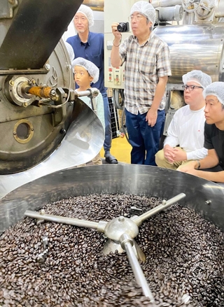 ブラジル産コーヒー豆の炭火焙煎を見学する参加者たち＝中央区港島南町４