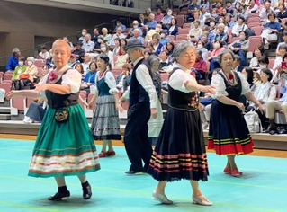 来場者にフォークダンスを披露するグループ＝神戸市北区しあわせの村