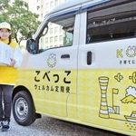「こべっこウェルカム定期便」の配達員と配達車＝神戸市役所