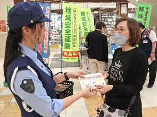 啓発文と炭酸せんべいを配る有馬署員（左）ら＝イオンモール神戸北
