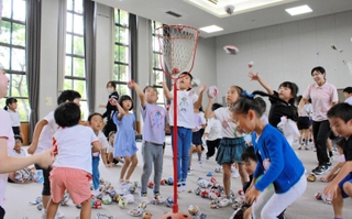 新聞で作ったボールで玉入れをする子どもたち＝甲南小