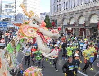 龍の舞に励まされるランナー＝２０２３年１１月１９日、神戸市中央区
